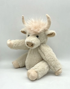 Close-up of the long shaggy fur texture on a beige highland cow plush toy