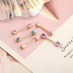 Macro view of six diverse surgical steel nipple bars in rose gold finish with colored gems
