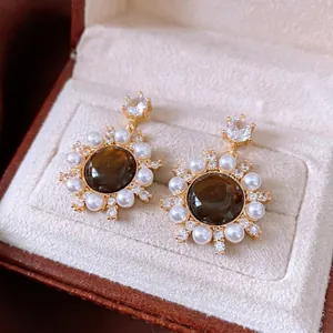 Vintage gold sunflower earrings with tiger eye stone, pearls, and zircons in jewelry box