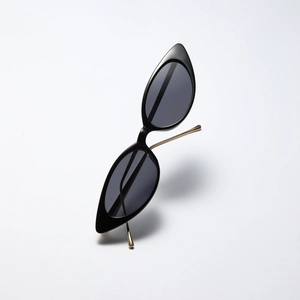 Chic black cat-eye sunglasses with slim gold metal temples on a white background