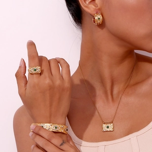 Golden evil eye jewelry set with malachite and zircons worn by a female model