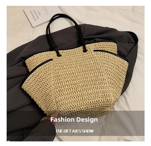 Detail of beige woven straw tote bag with black faux leather handles and mesh texture