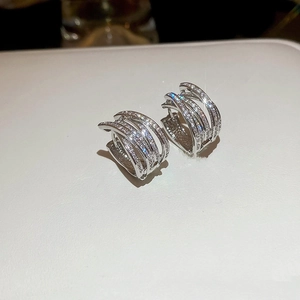 Macro shot of silver multi-layer crisscross earrings featuring sparkling cubic zirconia