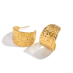Minimalist wide gold hoop earrings with irregular hammered texture on white background