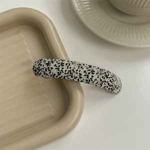 Close-up of acetic acid hair clip with black and white marble pattern on a tray