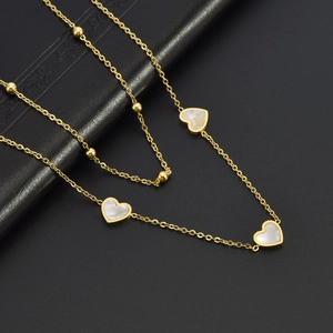 Double-layered gold titanium necklace with beads and heart-shaped white shell pendants