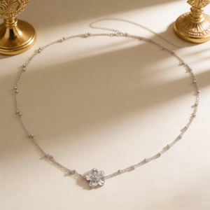 Detail van de boheemse frangipanibloem-hanger met zilveren kralenketting voor dames
