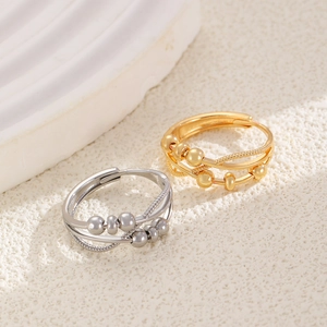 Detail of interlocking gold and silver infinity rings with movable spinning beads