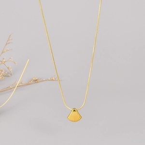 Golden scallop shell pendant necklace on a sleek snake chain with a minimalist style