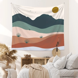 Detail of bohemian tapestry featuring abstract landscape with terracotta sun and desert cacti