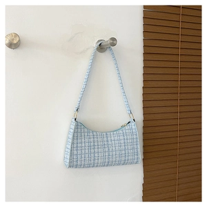 Détail du tissu en laine à carreaux bleu clair et boucle en métal du sac à bandoulière