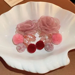 Elegant mesh flower earrings with soft pink petals and pearls in a white shell dish
