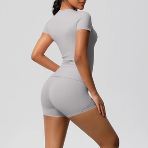 Detail of light gray slim fit yoga set featuring moisture-wicking short sleeve and shorts