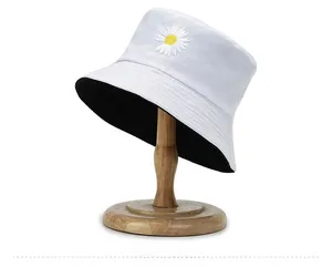 Detail of reversible cotton bucket hat with white daisy embroidery and black lining