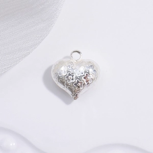 Detailed macro view of S925 silver heart pendant with 3D embossed floral patterns