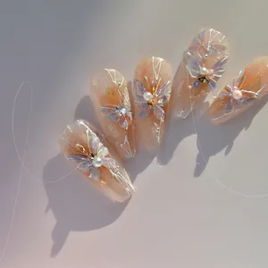 Detail showing 3D butterfly charms and pearls on pink glitter press-on nail stickers