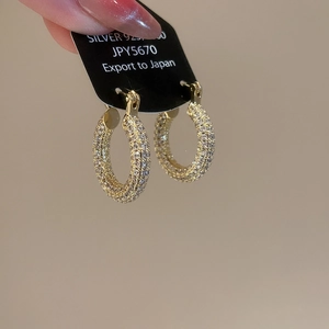 Detailed macro view of S925 sterling silver U-shaped gold hoop earrings with pavé zircon