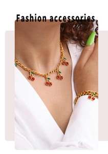 Close-up of a gold Cuban chain set with red crystal cherry pendants on a model