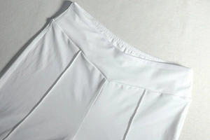 Close-up of white high-waisted trousers detailing fine stitching and elastic fabric