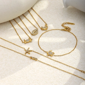 Detailed close-up of 18K gold plated ocean-themed charms with sparkling zircon pavé