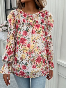 Detail of floral print blouse featuring smocked chest design and long sleeves