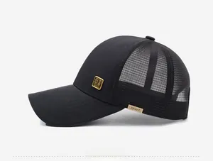 Side view of black mesh trucker hat with breathable panels and golden metal logo plaque