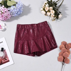 Detail of burgundy faux crocodile leather shorts with elastic waist and wavy hemline