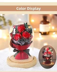 Detailed close-up of a preserved red rose bouquet in a glass dome with LED string lights