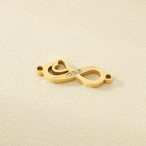 Close-up of golden infinity heart pendant with sparkling rhinestones for jewelry making