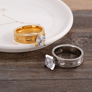 Detailed close-up of gold and silver plated rings with round zircons on ceramic plate