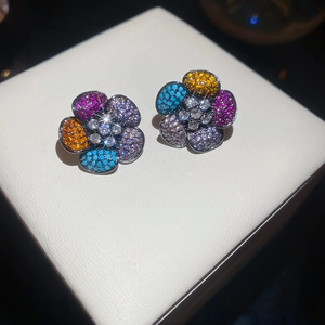 Macro view of flower stud earrings with multi-colored cubic zirconia and black gold finish