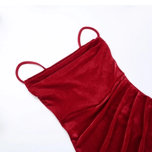 Detailed close-up of dark red velvet dress featuring thin straps and ruching textures