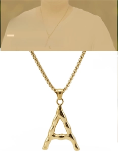 Macro detail of a liquid-textured gold letter A pendant with a classic box chain