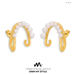 Close-up of golden irregular hoop earrings with six white pearls on white background