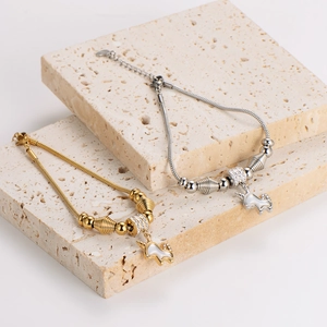 Gold and silver unicorn charm bracelets with mother of pearl on stone display blocks