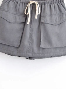 Detail of grey cargo skirt with elastic drawstring waist and large flap pockets