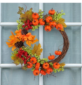 Detailed view of autumn wreath with orange pumpkins, maple leaves and berries on white window