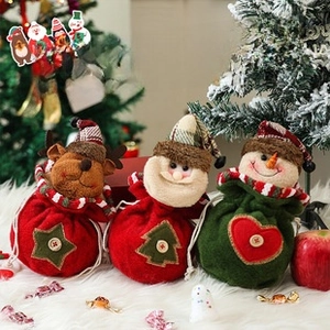 Three Christmas drawstring gift bags featuring reindeer, Santa, and snowman on plush white fur