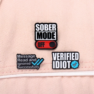 Trois pin's émaillés SOBER MODE OFF et VERIFIED IDIOT sur tissu denim rose