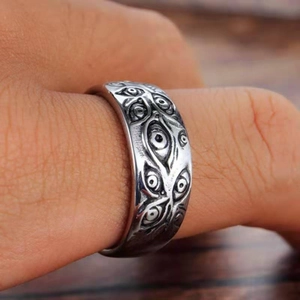 Gothic silver metal ring with all-around evil eye engravings worn on a finger