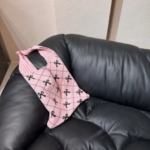Nahaufnahme der rosa Stricktasche mit schwarzen Schleifenmustern und Rautenstruktur