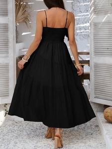 Back view of elegant black multi-layered tiered maxi dress on a vacation backdrop
