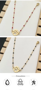 Close-up of gold chain bracelets with hollow pet paw pendants and colorful beads