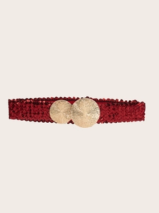 Detailed view of a wide red sequin belt featuring a stylish gold circular metal buckle