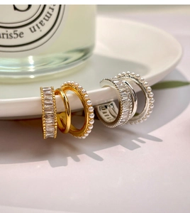 Detailed view of gold and silver ear cuffs with square zircon and micro pearl trim