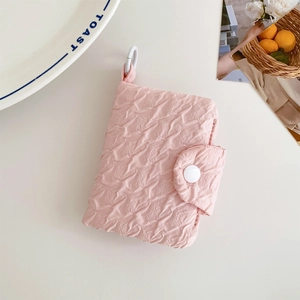 Dettaglio del porta carte rosa con trama a bolle e chiusura con bottone a pressione