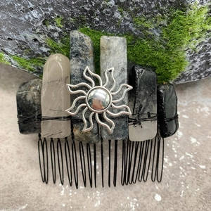 Detailed view of natural crystal stones and silver sun charm on a handcrafted hair comb