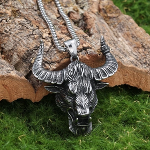 Viking style silver stainless steel bull head pendant on rustic wood and moss