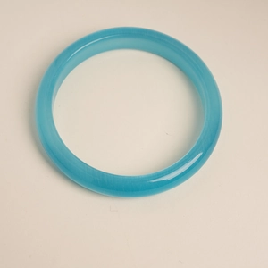 Macro detail of sky blue cat eye stone bangle with smooth flat band design