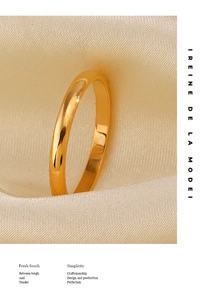 Polished gold stainless steel minimalist band ring placed on elegant silk fabric